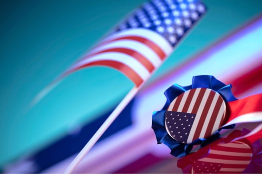 An american flag on a staff, waving in the wind with a clear blue sky and distant mountains as its backdrop, symbolizing usa independence day photo