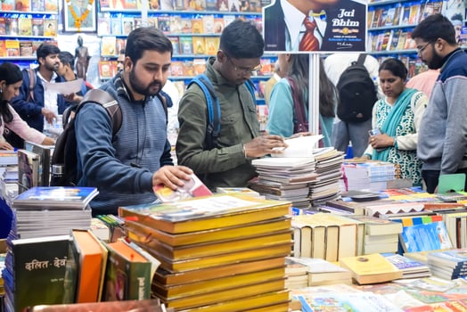 Delhi, India, July 12 2024 - Various age group people reading variety of Books on shelf inside a book-stall at Delhi International Book Fair, Books in Annual Book Fair at Bharat Mandapam complex photo
