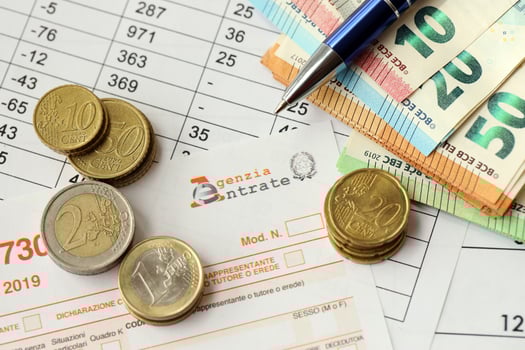 KYIV, UKRAINE - APRIL 20, 2024 Agenzia Entrate logo from blank tax form and many euro banknotes on office table photo