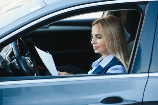 Fashion business woman with financial papers by her car photo
