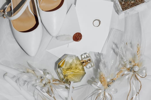 A pair of white shoes and a bottle of perfume are on a table photo