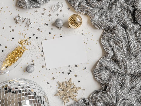 Flat lay of Christmas or New year party disco ball, dress, season decoration and empty white postcard on white background. photo