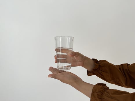 Healthy lifestyle concept. Young woman holding transparent water glasses photo