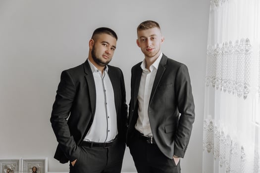 Two men in suits are standing next to each other. They are both wearing white shirts and black suits photo
