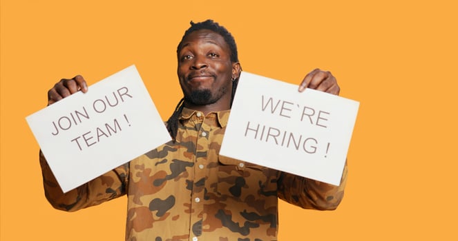 Job recruiter putting hiring messages and ads on papers to obtain new personnel for job vacancy at multinational company. African american employee managing recruitments and interviews. photo