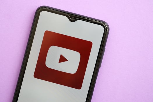 KYIV, UKRAINE - APRIL 1, 2024 Youtube icon on smartphone screen on purple table photo