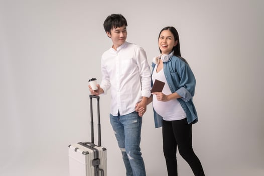 Portrait of Beautiful pregnant woman and husband traveling over white background studio, insurance and maternity concept photo