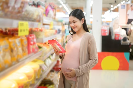 Beautiful pregnant woman shopping bakery and bread at grocery shop photo