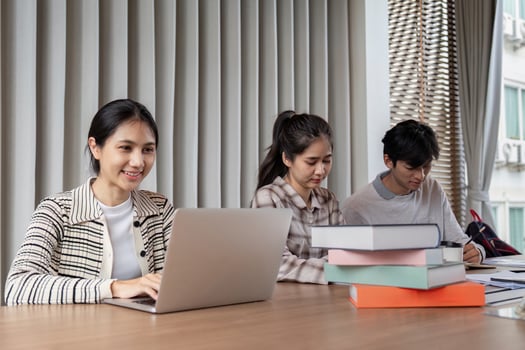 Group of Focused Student Study Together with Laptops and Books in a Modern Classroom Setting photo