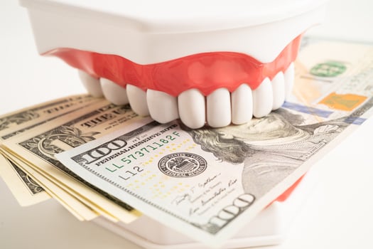 Treatment dental care cost, dental expense or fee, US dollar banknote money with teeth model. photo