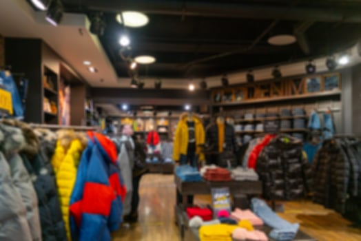 Blurry interior of a sportswear shop. Mannequin in a modern suit. photo