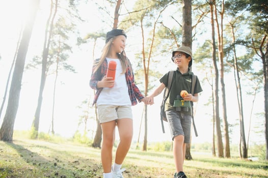 Little boy and girl go hiking on a forest road photo