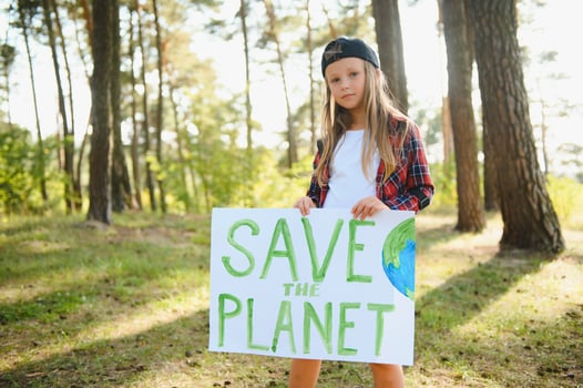 caucasian blonde girl activist with save the planet poster in park. preteen kid volunteer against pollution, global warming, recycle garbage. Ecology environmental problem. photo