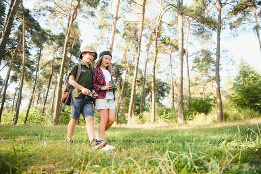 Little boy and girl go hiking on a forest road photo