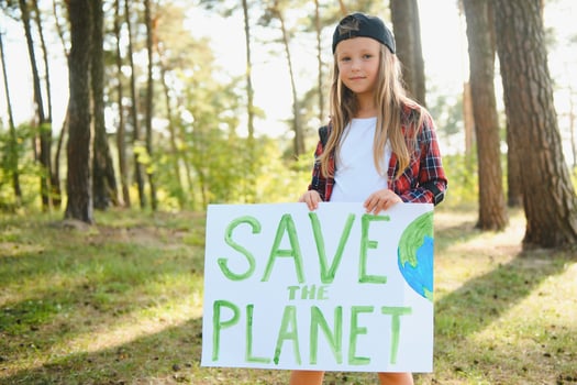 caucasian blonde girl activist with save the planet poster in park. preteen kid volunteer against pollution, global warming, recycle garbage. Ecology environmental problem. photo