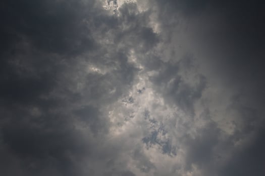 Black clouds in the sky in the rainy season are the formations of a rain storm in the evening. The background of the sky full of black dark rain clouds photo