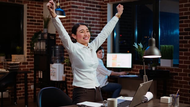 Happy worker jumping from office chair, feeling excited after learning of upcoming promotion, rewarded for good results. Cheerful employee exulting from joy, celebrating, camera A photo