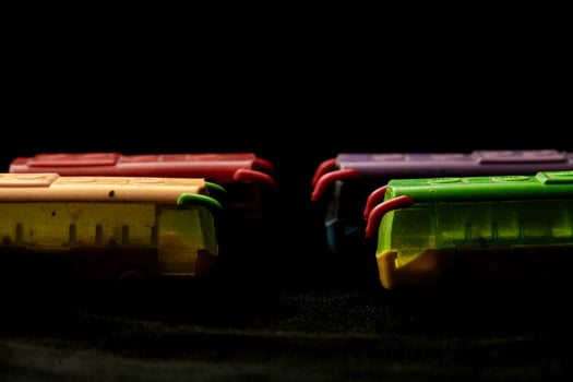 Colorful miniature bus made of plastic and black background photo