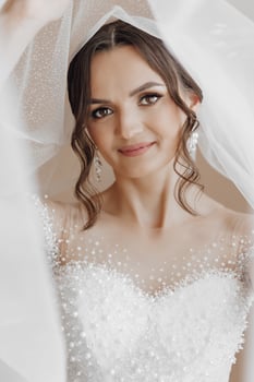 A woman is wearing a white dress and a veil photo