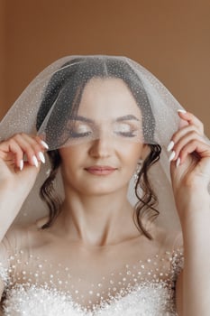 A woman is wearing a veil and holding her hand over her face photo