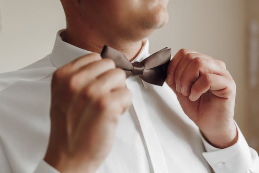 A man is getting ready to tie his bow tie photo