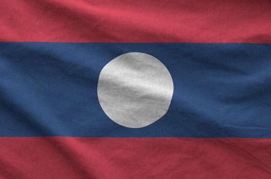 Laos flag depicted on folded wavy fabric of old cloth photo