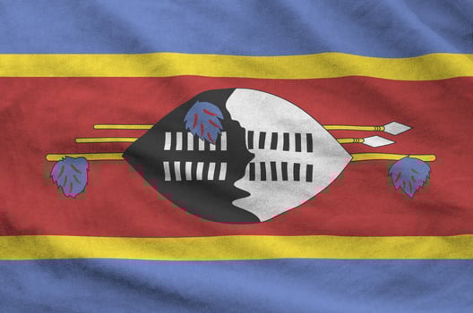 Swaziland flag depicted on folded wavy fabric of old cloth photo