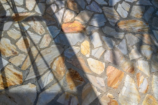 Modern beige, brown and gray stone masonry wall texture background with floral sun light shadow. photo
