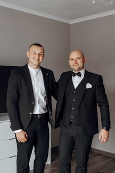 Two men in suits are posing for a picture. One of them is wearing a bow tie. Scene is formal and professional photo