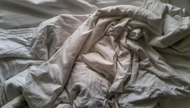 Texture of crumpled fine white cotton fabric as background. Shabby bed sheets. top view. photo