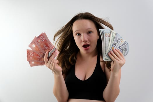 Girl Canadian dollars American dollars Exchange Learning Concept. Studio portrait of pretty young student woman holding passport with tickets and money. photo