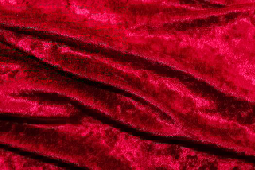 Texture of red velor corduroy fabric with folds photo
