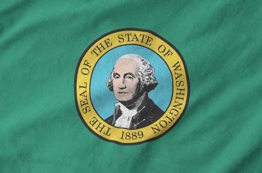 Washington US state flag depicted on folded wavy fabric of old cloth photo