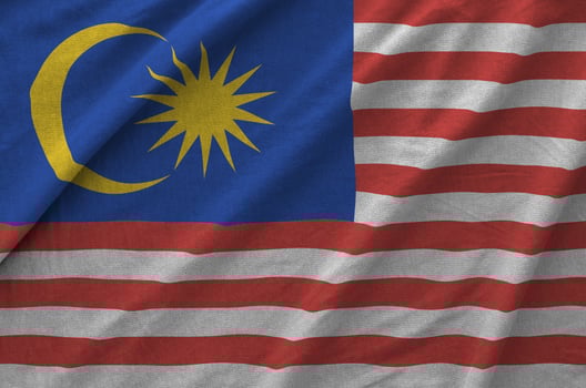 Malaysia flag depicted on folded wavy fabric of old cloth photo