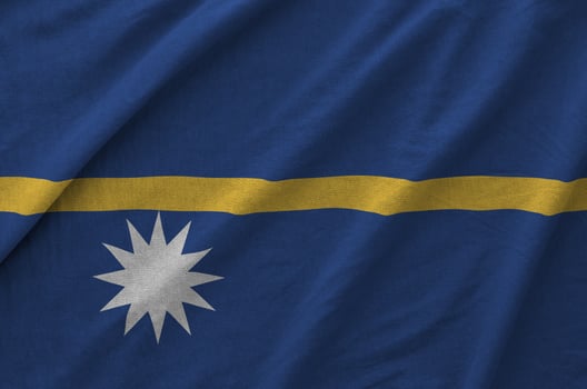Nauru flag depicted on folded wavy fabric of old cloth photo