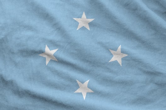 Micronesia flag depicted on folded wavy fabric of old cloth photo