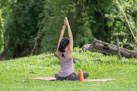 Young Woman Practicing Yoga Outdoors in a Lush Green Garden, Finding Peace and Relaxation in Nature photo