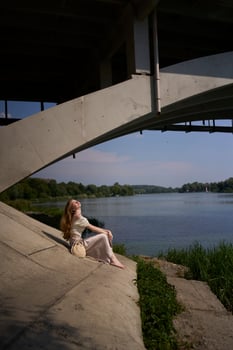 beautiful teenage girl in a silk skirt and corset in the old money style. Fashion photoshoot under the bridge. photo