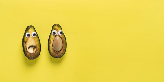Spoiled rotten fruit vegetables cheerful avocado with yellow eyes against background copy space photo