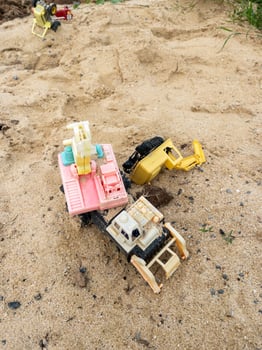 The broken excavator toy in the sandbox. photo