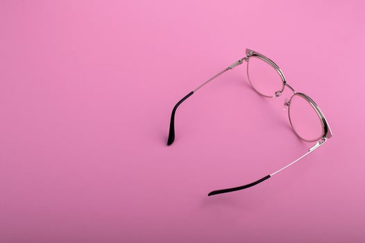 Black frame eyeglasses isolated on pastel pink color background photo