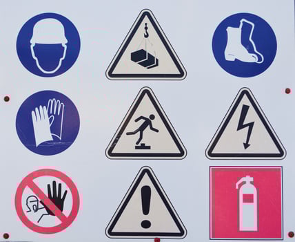 A board with warning signs about danger that stands before the start of construction on the field photo