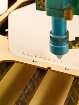 Laser cutting plywood and engraving wood inscription text November specialized machine cut tree on sawmill. close-up, vertical, inside photo