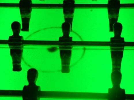 A retro-illuminated foosball table with a vibrant green glow creates an energetic and nostalgic atmosphere, perfect for adding a playful touch to any setting. photo