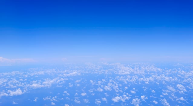 Horizontal gradient blue sky with white fluffy clouds photo