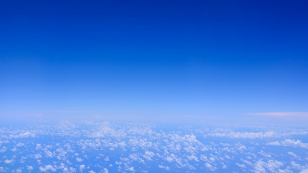 Horizontal gradient blue sky with white fluffy clouds photo