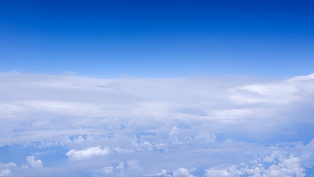 Horizontal gradient blue sky with white fluffy clouds photo