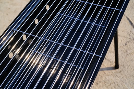 Close-up shot of stainless steel grill tray. Charcoal grill. Standing grill. Grill and barbeque. Outdoor party. Cooking tools. Kitchen set. Kitchen equipment photo concept
