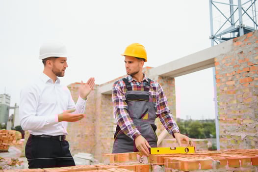 Builder and engineer on construction site photo