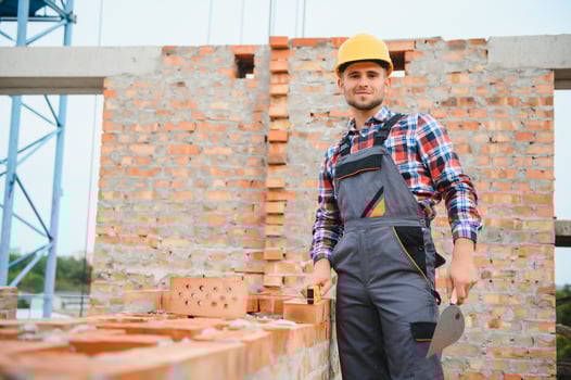 Construction worker in uniform and safety equipment have job on building photo